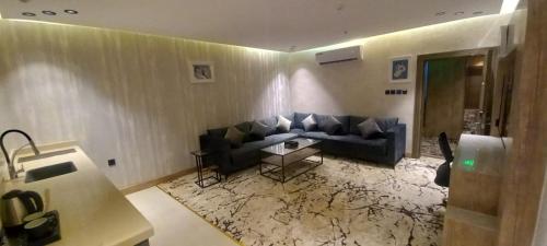 a living room with a couch and a table at فندق حياة تاون 2 in Umm Lujj