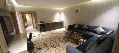 a living room with a blue couch and a kitchen at فندق حياة تاون 2 in Umm Lujj