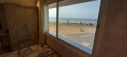a bathroom with a window with a view of the beach at فندق حياة تاون 2 in Umm Lujj