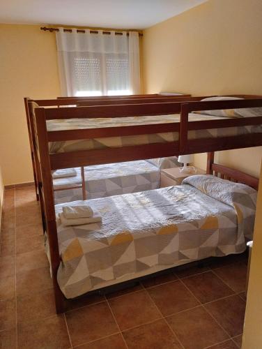 two bunk beds in a room with a window at Apartamento MG in Ayamonte