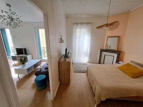 - une chambre avec un grand lit et une cheminée dans l'établissement T2 climatisé avec balcon à proximité du centre ville, à Béziers