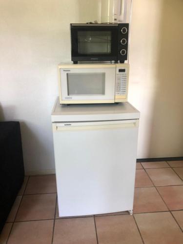 a microwave sitting on top of a white refrigerator at Hoeve Het Verre Einder in Heythuysen