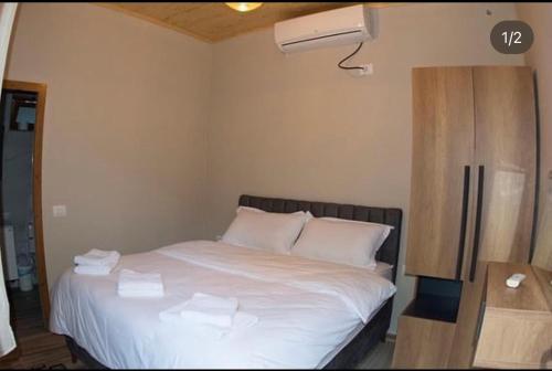 1 dormitorio con 1 cama con toallas en Te Cemi - Restorant - Hotel, en Tamarë