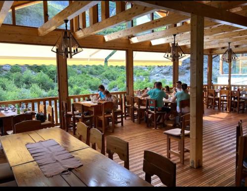 un grupo de personas sentadas en mesas en un restaurante en Te Cemi - Restorant - Hotel, en Tamarë