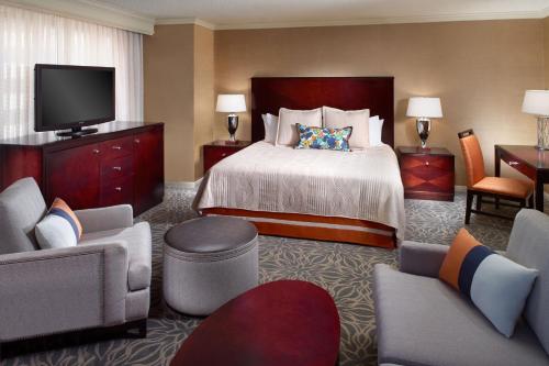 Marriott Jacksonville Downtown في جاكسونفيل: غرفة فندقية بسرير وتلفزيون بشاشة مسطحة