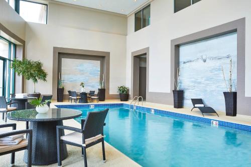 a swimming pool with a table and chairs and a table and a pool at Renaissance Chicago Glenview Suites Hotel in Glenview