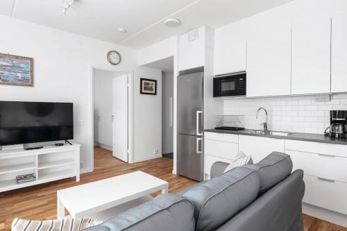 a living room with a couch and a kitchen at Brand new home in Barkabystaden in Barkarby