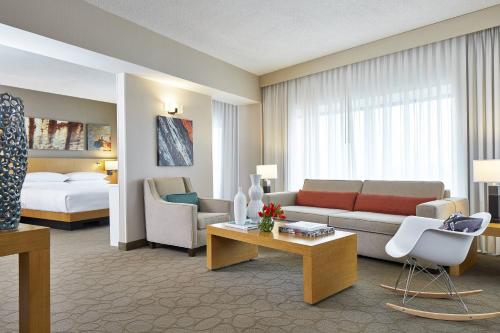 a living room with a couch and a bed at Renaissance Chicago Glenview Suites Hotel in Glenview