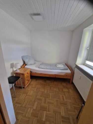 a small room with a bed and a wooden floor at Monteurwohnungen - Monteurunterkunft in Randersacker bei Würzburg in Randersacker