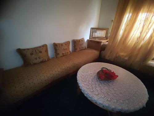 a couch with a table with a flower on it at اسفي سعيدة 2 in Safi