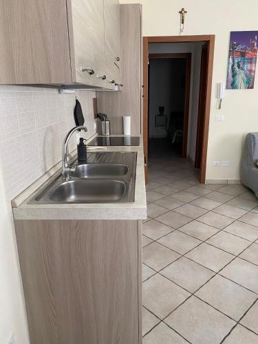 una cucina con lavandino e pavimento piastrellato di Saba's House a Ghizzano
