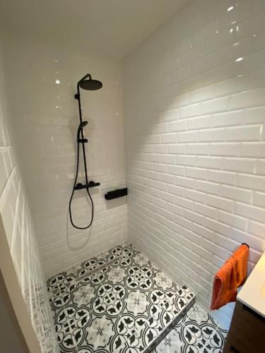 a bathroom with a shower with a tiled floor at Paardenhuisje in Sint-Lievens-Houtem