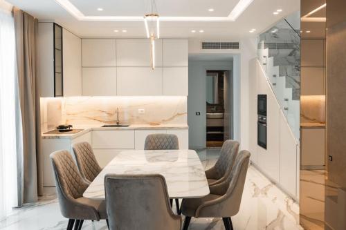 a dining room with a table and chairs and a kitchen at Palmera Gold Vila in Sarandë