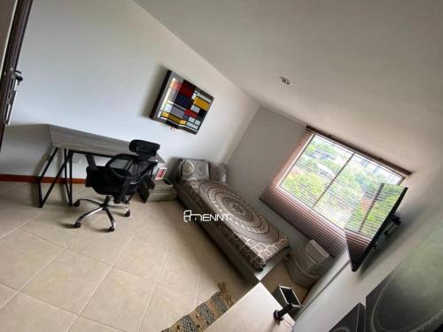 Cette chambre dispose d'un bureau, d'une chaise et d'une fenêtre. dans l'établissement Beautiful apartment in Envigado, à Envigado