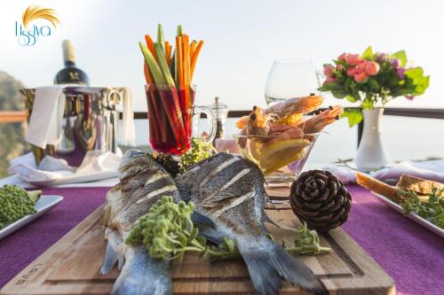 a table with vegetables on a wooden cutting board at Lissiya Hotel in Faralya