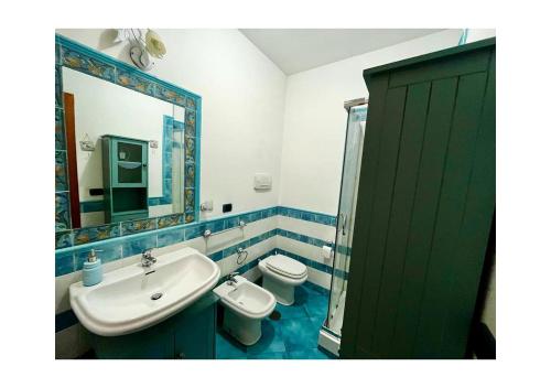 La salle de bains est pourvue d'un lavabo, de toilettes et d'un miroir. dans l'établissement Villa Ortensia, à Brindisi