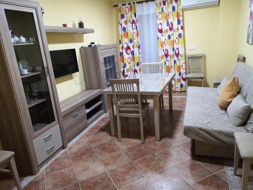 - un salon avec une table et un canapé dans l'établissement Apartamento MG, à Huelva