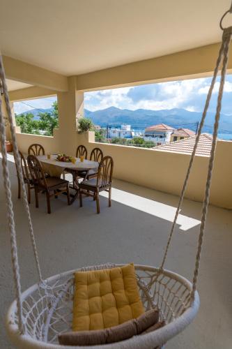 a swing in a room with a table and a balcony at A&S Seaside House in Lixouri