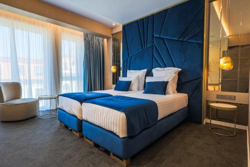 Habitación de hotel con cama grande y cabecero azul en HOTEL NOVA LUXURY, en Târgovişte