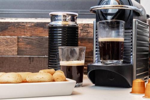 a coffee maker and a glass of beer and a plate of food at מאיורי בוטיק - וילה מקסימה עם בריכה פרטית ונוף מהמם למשפחות בלבד in Mishmār Hāyardin