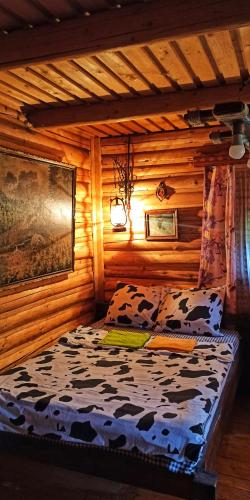 a bedroom with a bed in a log cabin at Еко Садиба Під Полониною in Sasivka