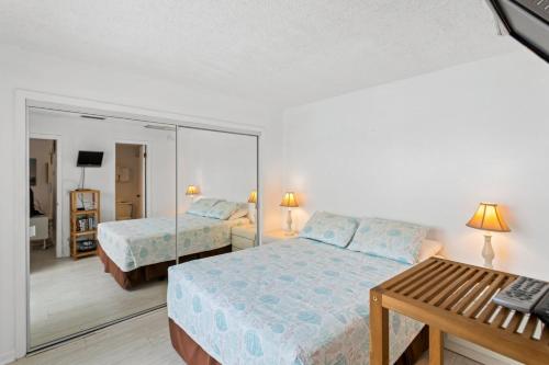 a bedroom with two beds and a mirror at #231 F Madeira Beach Yacht Club in St. Pete Beach