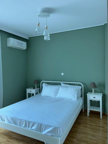 a bed in a blue room with two tables at anastasis house in Athens