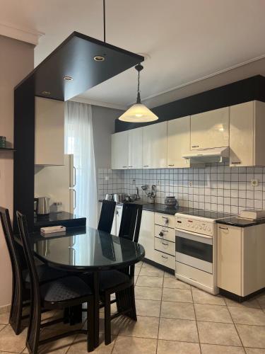 a kitchen with a table and chairs and a kitchen with white appliances at anastasis house in Athens
