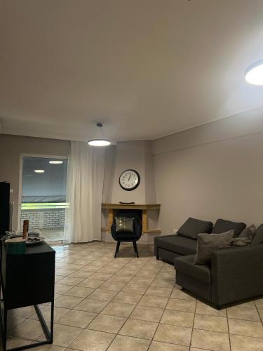 a living room with a couch and a clock on the wall at anastasis house in Athens
