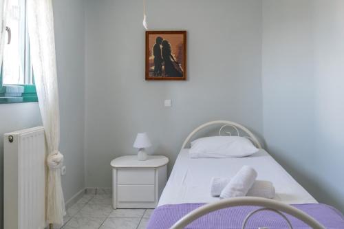 a bedroom with a bed and a picture on the wall at A&S Seaside Maisonette in Lixouri