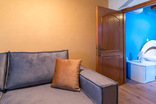 a couch with a pillow sitting in a room at A&S Seaside Maisonette in Lixouri