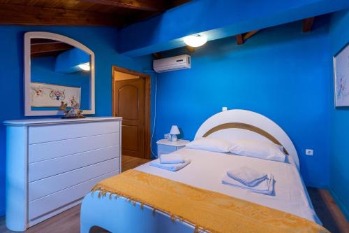 a blue bedroom with a bed and a dresser at A&S Seaside Maisonette in Lixouri