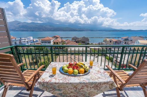 a plate of fruit on a table on a balcony at A&S Seaside Maisonette in Lixouri