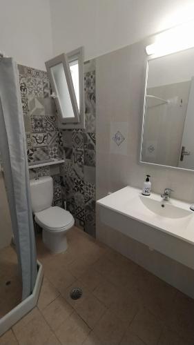a bathroom with a sink and a toilet and a mirror at Marianos Apartments in Antiparos