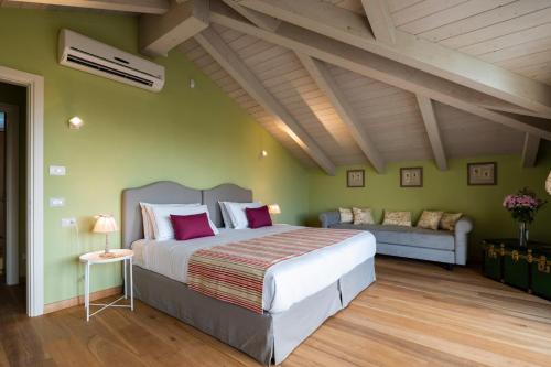 a bedroom with a large bed and a couch at Casa San Grato in Monteu Roero