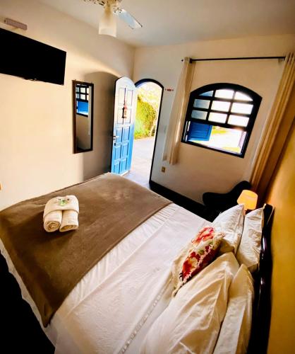 a bedroom with a bed and a window and a door at Pousada Recanto Verdes Mares in Arraial do Cabo