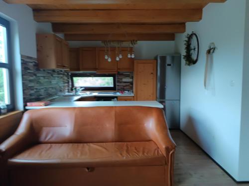 a kitchen with a brown leather couch in a kitchen at Csencsó Vendégház in Ciumani