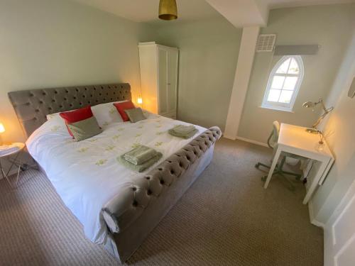 a bedroom with a large bed and a window at Birdsong & Pine: parking & garden in Worthing