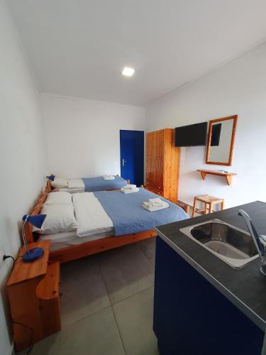 a bedroom with a large bed and a sink at Babis & Popi Rooms and Studios in Frangokastello