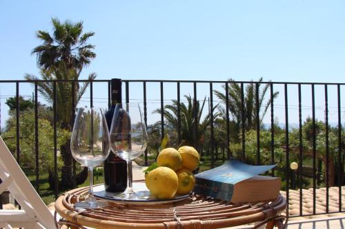 una mesa con una bandeja de fruta y copas de vino en La Villa Rosa al Mare, en Pozzallo