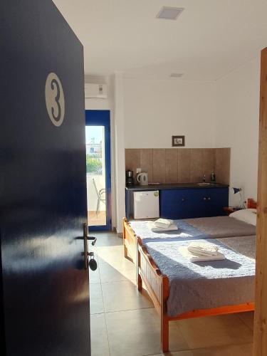 a bedroom with a bed with a blue bedspread at Babis & Popi Rooms and Studios in Frangokastello