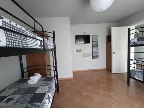 Pokój z 2 łóżkami piętrowymi i telewizorem w obiekcie Demis Apartments w Sidari