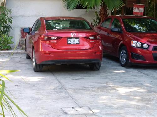 two red cars parked next to each other at Posada El Jardin in Ticul