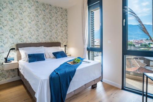 ein Schlafzimmer mit einem Bett und einem großen Fenster in der Unterkunft Homa Luxury Apartments Tivat with seaview in Donja Lastva