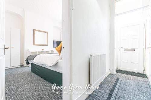 a white bedroom with a bed and a window at Goose Green Contractor Accommodation in Pemberton