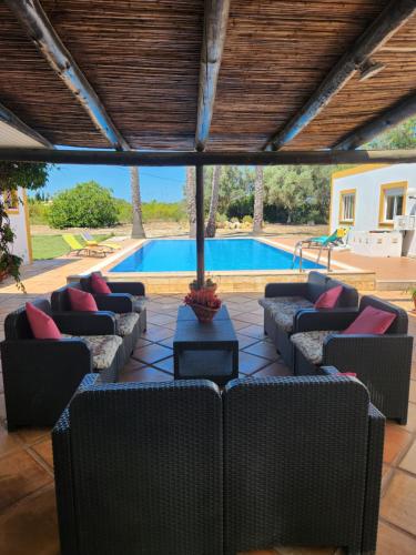 une terrasse avec des canapés et une piscine dans l'établissement Quinta Das Amendoas, à Carvoeiro
