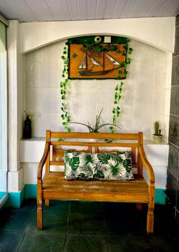 a wooden bench sitting in front of a wall at Pousada Recanto Verdes Mares in Arraial do Cabo