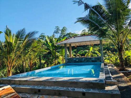 a swimming pool with a gazebo next to some palm trees at Tiny Royal Palace in Unawatuna