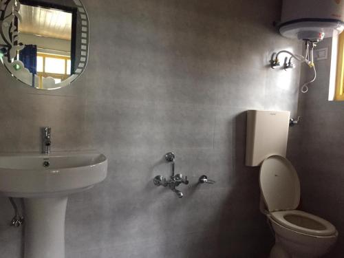ein Badezimmer mit einem Waschbecken, einem WC und einem Spiegel in der Unterkunft Hotel city way in Srinagar