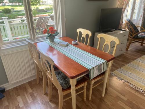 a dining room table with chairs and a television at Villa Verdi in Borgholm